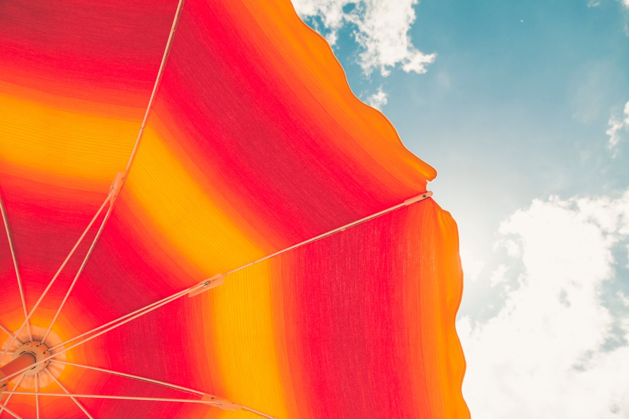 colorful beach umbrella with vivid stripes under a bright summer sky i