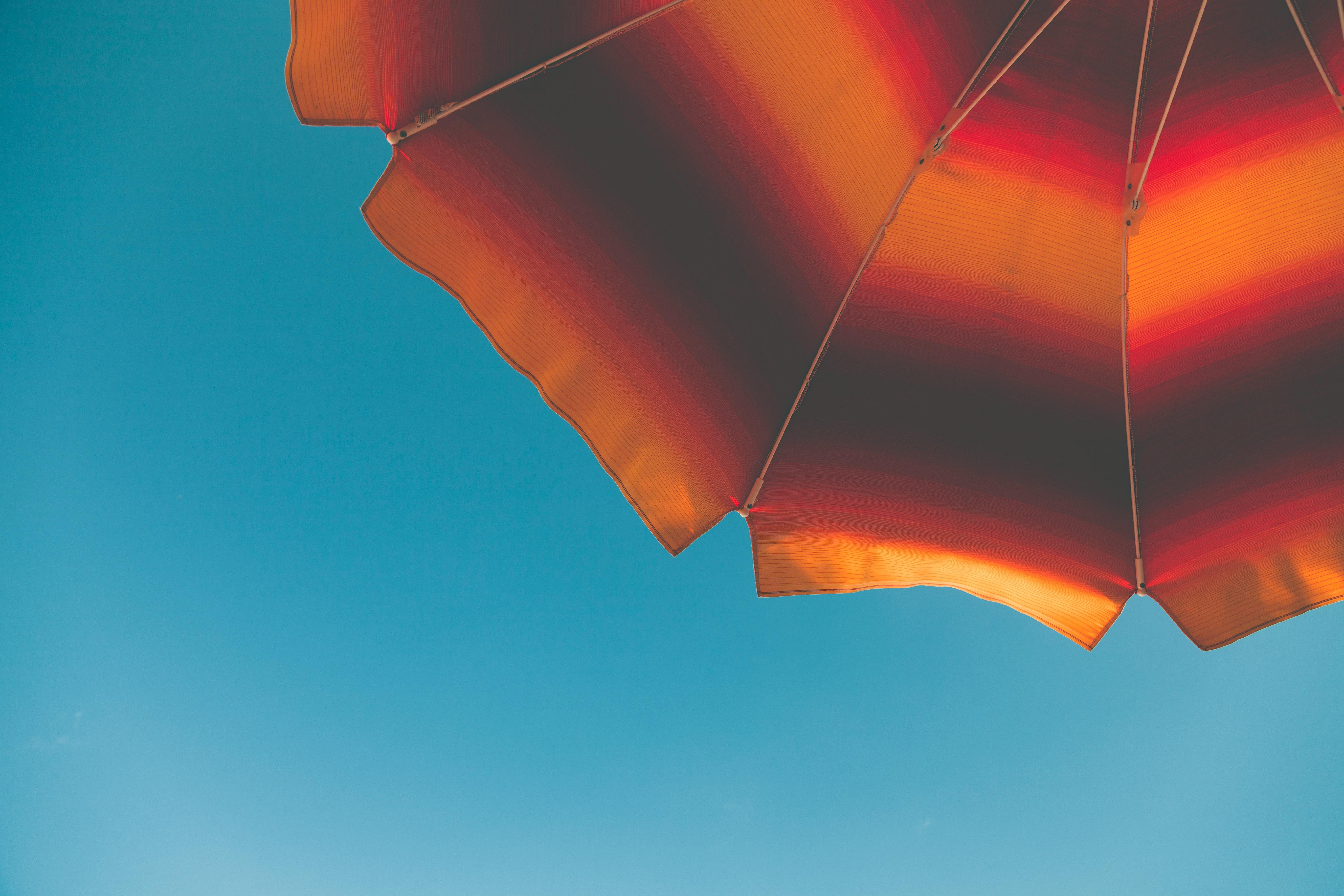 Low Angle Photography Of Black And Orange Beach Umbrella