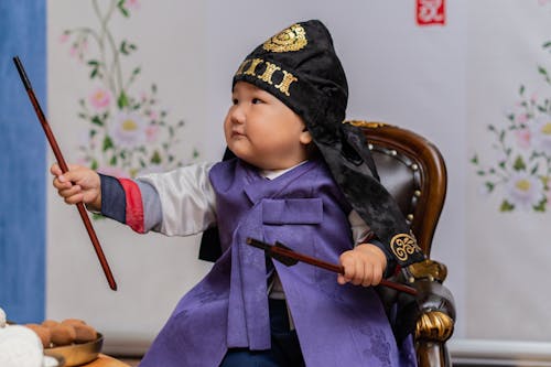 Baby in Traditional Clothes Holding Chopsticks