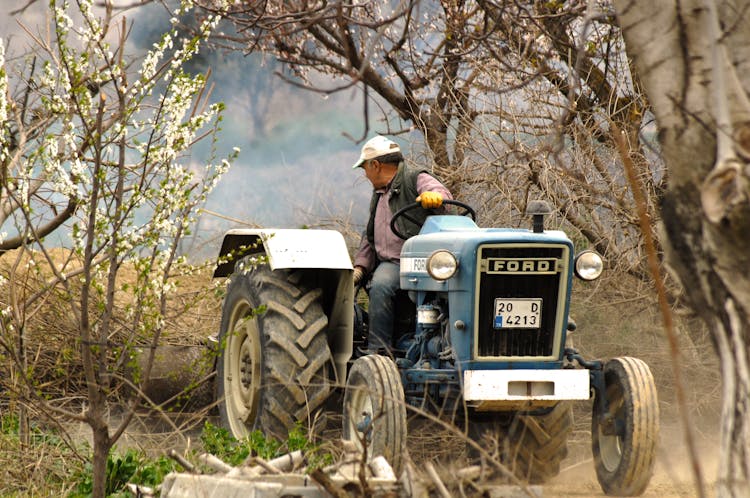 Man Driving A Tractor On Bushes