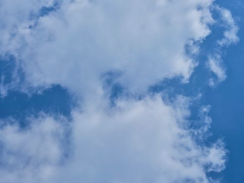 Free Tranquil image of a clear blue sky dotted with fluffy white clouds, perfect for serene and peaceful themes. Stock Photo