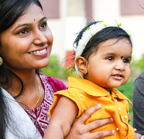 A Smiling Woman Carrying Her Daughter