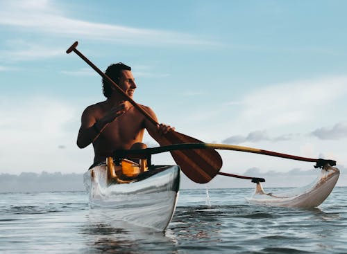 Man Riding on Boat Holding Brown Paddle