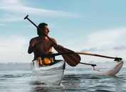 Man Riding on Boat Holding Brown Paddle
