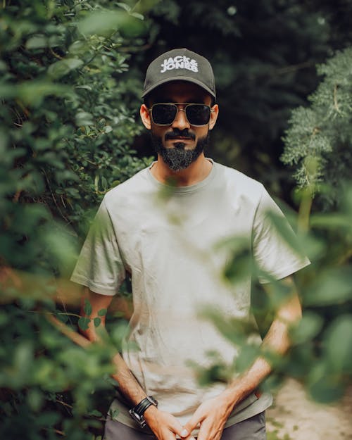 Bearded Man Wearing Sunglasses Standing Beside Green Plants