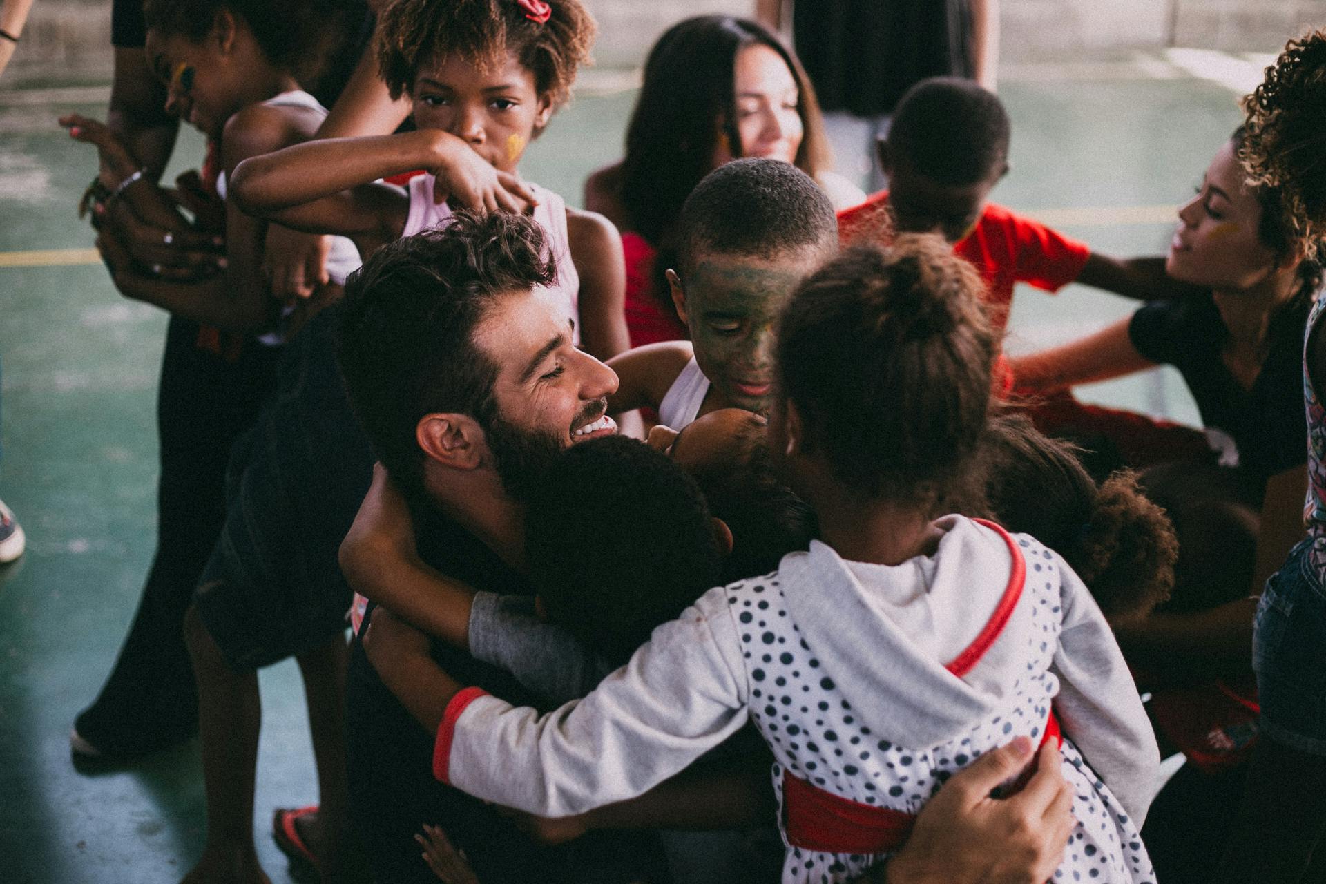 Joyful group hug at a community gathering in Vila Sarapui, Brazil.