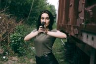 caucasian girl hold a gun. military girl. green t-shirt.