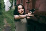 caucasian girl hold a gun. military girl. green t-shirt.