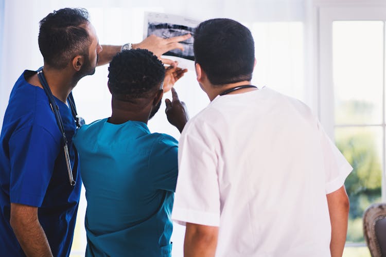 Three Person Looking At X-ray Result