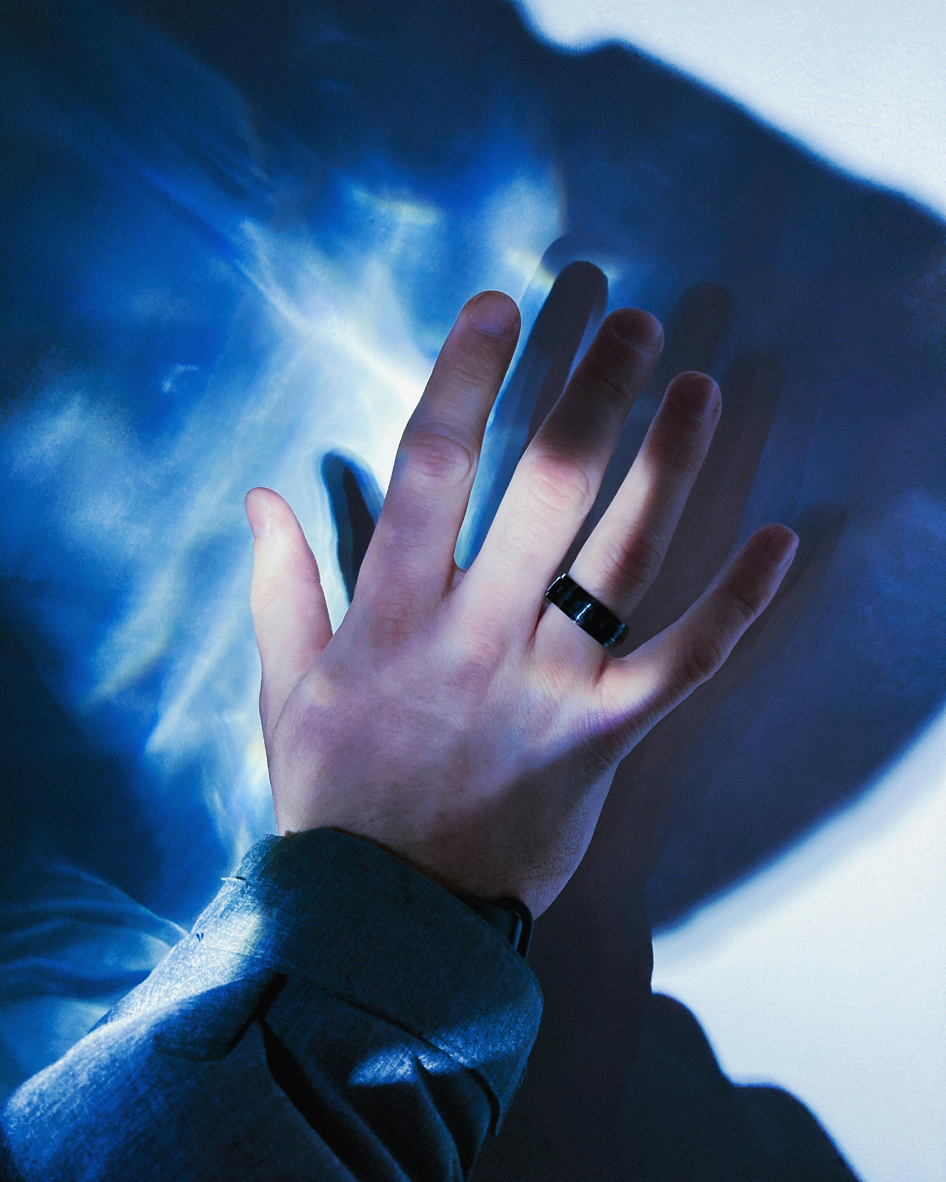 person s hand with black ring