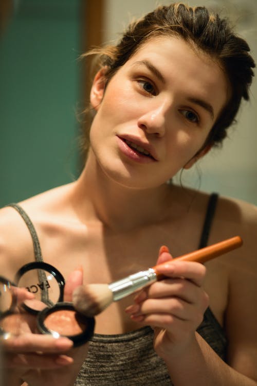 Woman Holding Highlighter and Makeup Brush