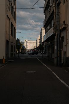 Street view capturing urban architecture and vehicles under a cloudy sky.