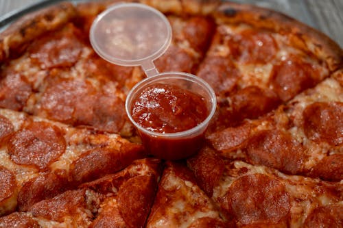 Close Up Shot of a Red Sauce in Plastic Container