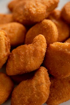Close-up of crispy, golden-brown chicken nuggets arranged together, highlighting texture.