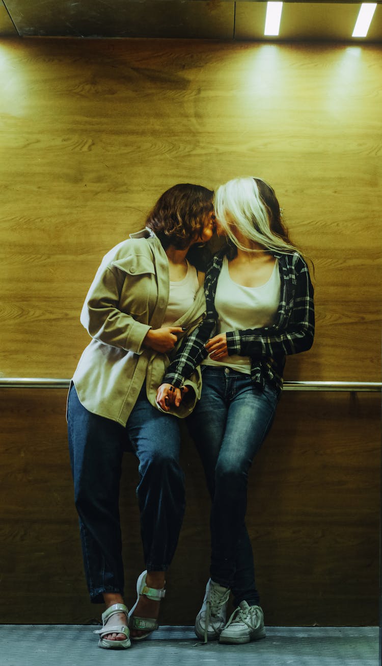 Women Kissing In Dimly Lit Room