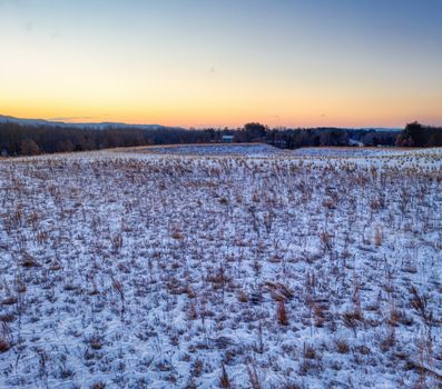 A serene winter sunrise over a snowy field in West Newton, Minnesota.