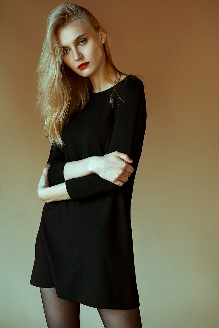 Portrait Of Woman In Black Dress Standing With Arms Crossed