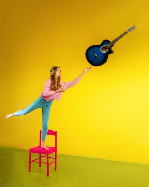 A Woman in Pink Sweater Standing on a Pink Chair