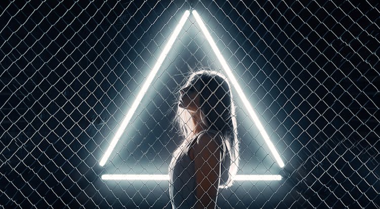 Woman Near A Metal Fence And Triangle Light