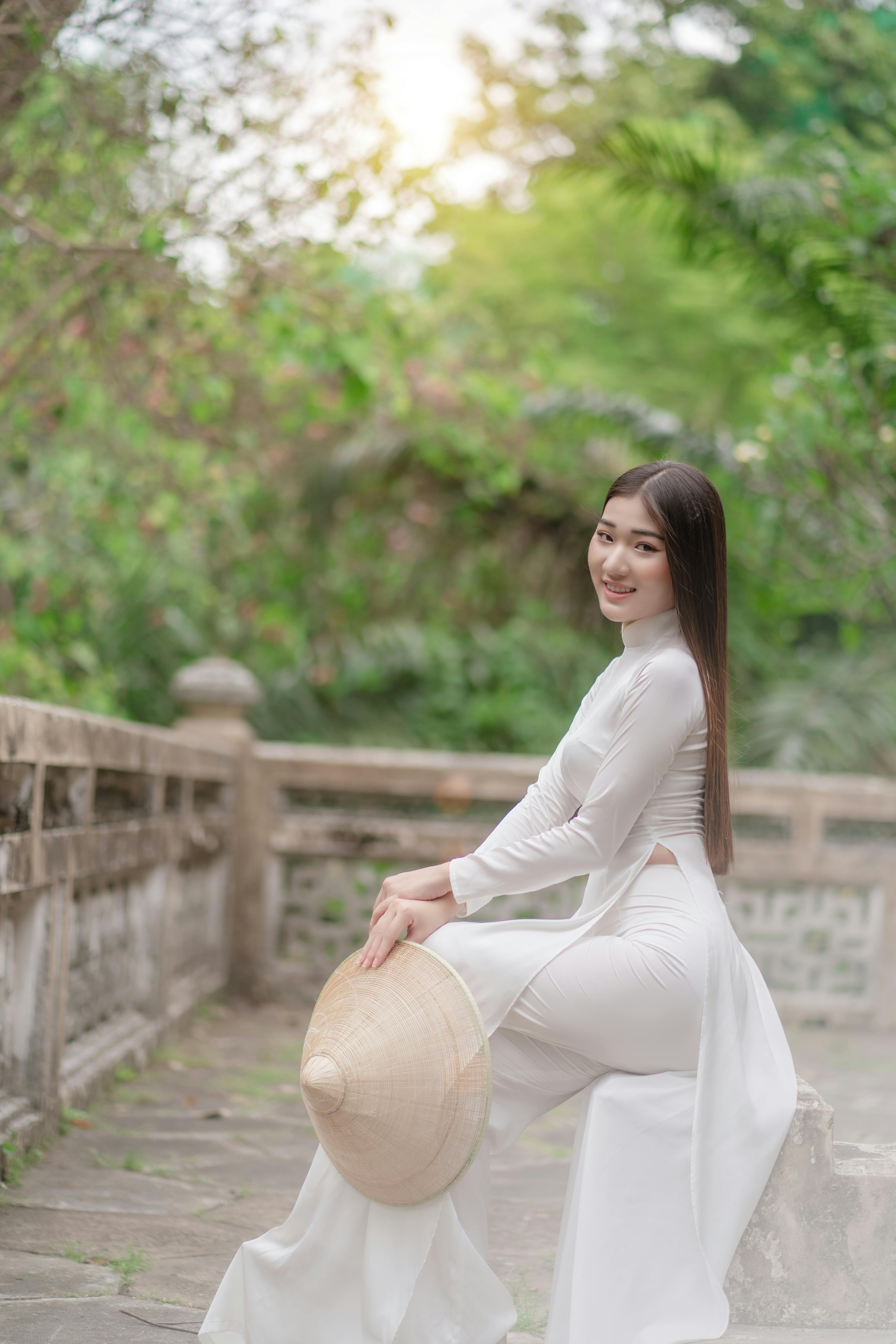 woman in white traditional wear holding a hat