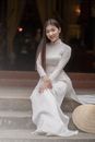 Woman in White Long Sleeve Dress Sitting on Gray Concrete Bench