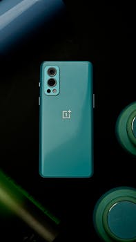 Flat lay of a sleek smartphone with tech accessories on a dark background.