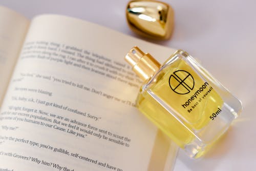 Close-Up Shot of a Glass Perfume Bottle on the Book
