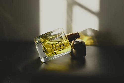 Close-Up Shot of a Glass Perfume Bottle on Gray Surface
