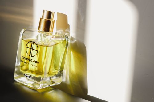 Free A stylish perfume bottle casting a shadow in warm sunlight, enhancing its luxurious appearance. Stock Photo