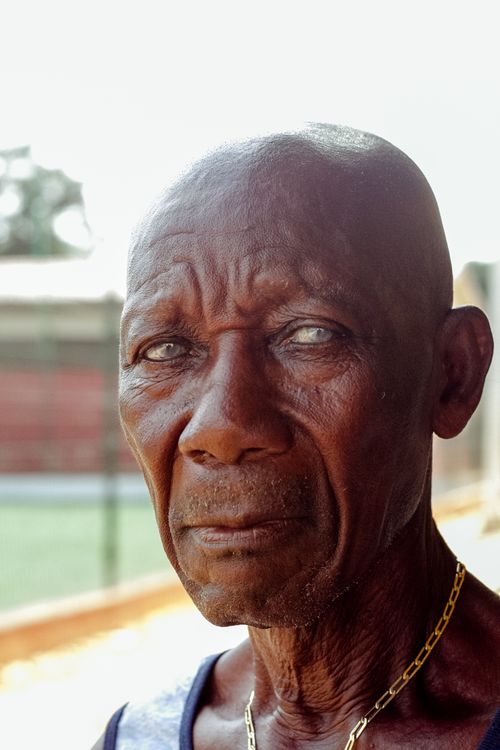 Free Close-up portrait of a senior man with a serious expression, captured outdoors. Stock Photo