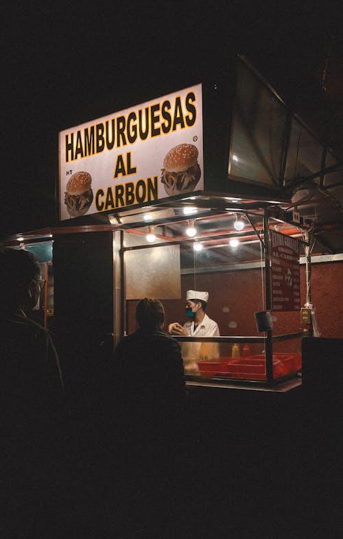 People Lined up at a Hamburger Stall