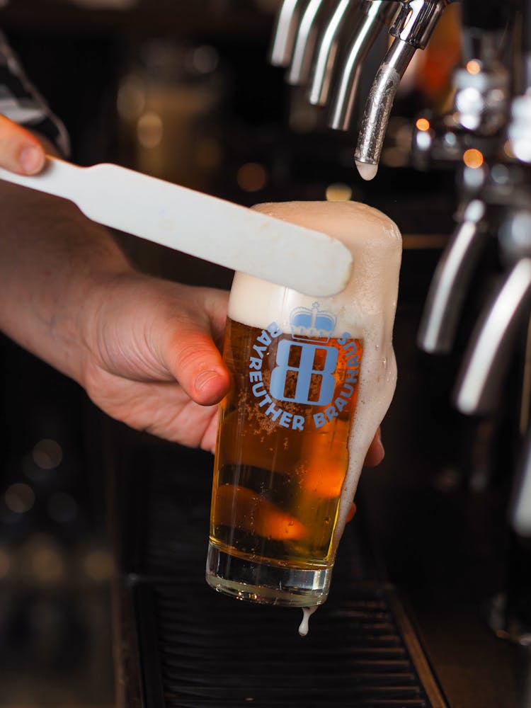 A Hand Refilling A Beer