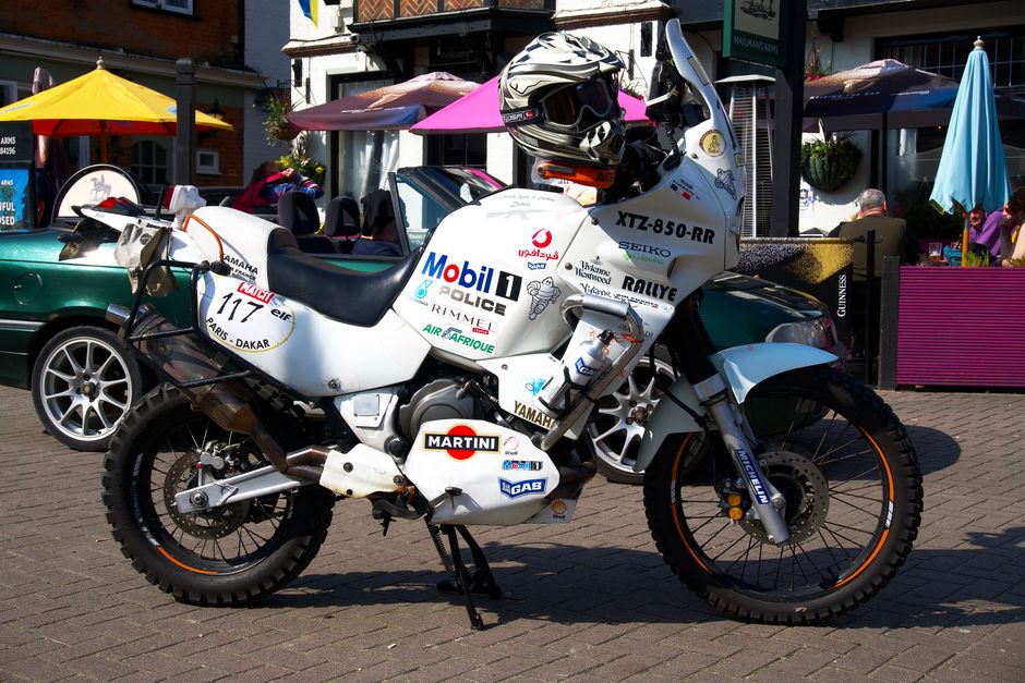 Classic Yamaha motorbike with racing decals parked in Lyndhurst, UK on a sunny day.