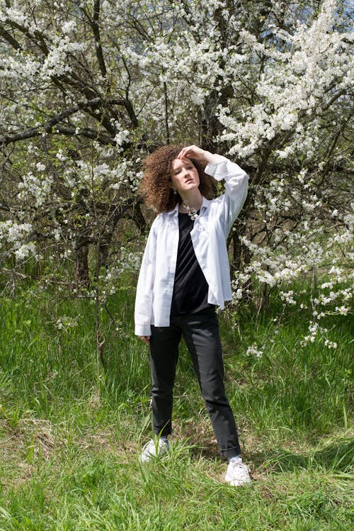 Foto stok gratis belukar, bunga sakura, celana hitam