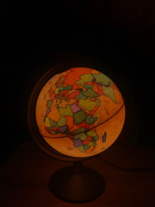 Free A glowing globe displaying continents and countries on a dark background. Stock Photo
