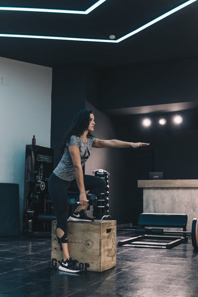 Young Woman In Gym Clothes Performing Exercise