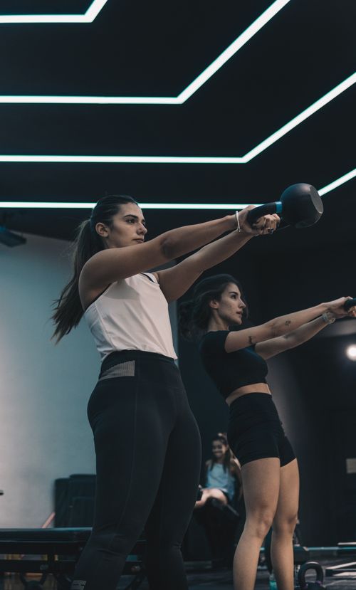 Free Two women workout with kettlebells indoors, showcasing strength and fitness dedication. Stock Photo