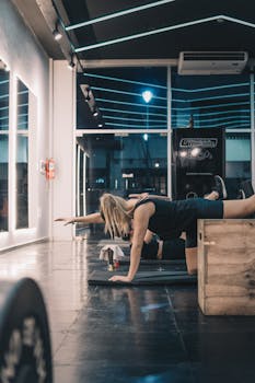 A woman performing core stability exercises indoors in a modern gym setting.