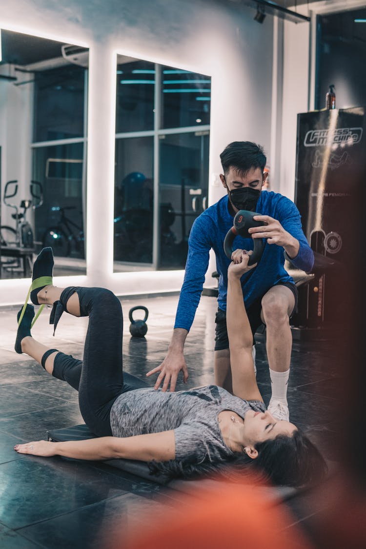 A Man Training A Woman In The Gym