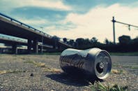 立交桥附近躺着一个废弃的可口可乐罐，展现了城市垃圾的状况