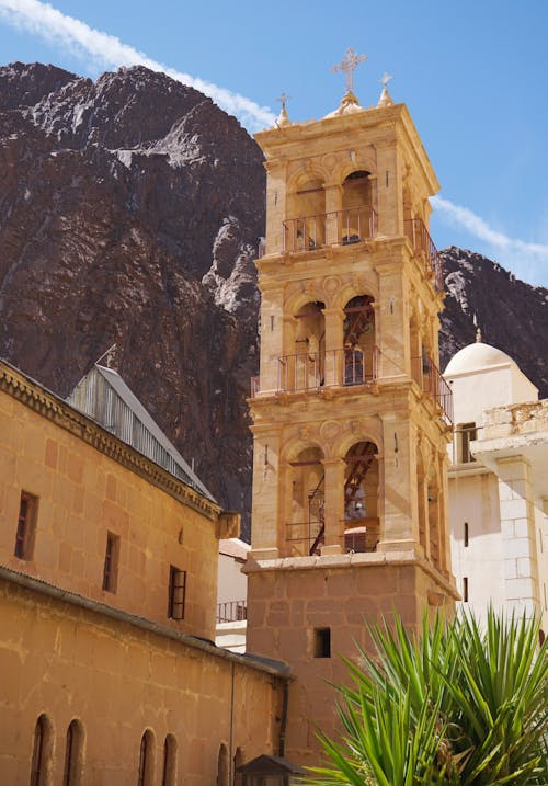 Bell Tower of a Church Near a Rocky Mountain