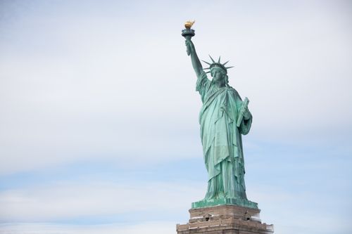 Free The iconic Statue of Liberty stands proudly against a cloudy sky in New York. Stock Photo