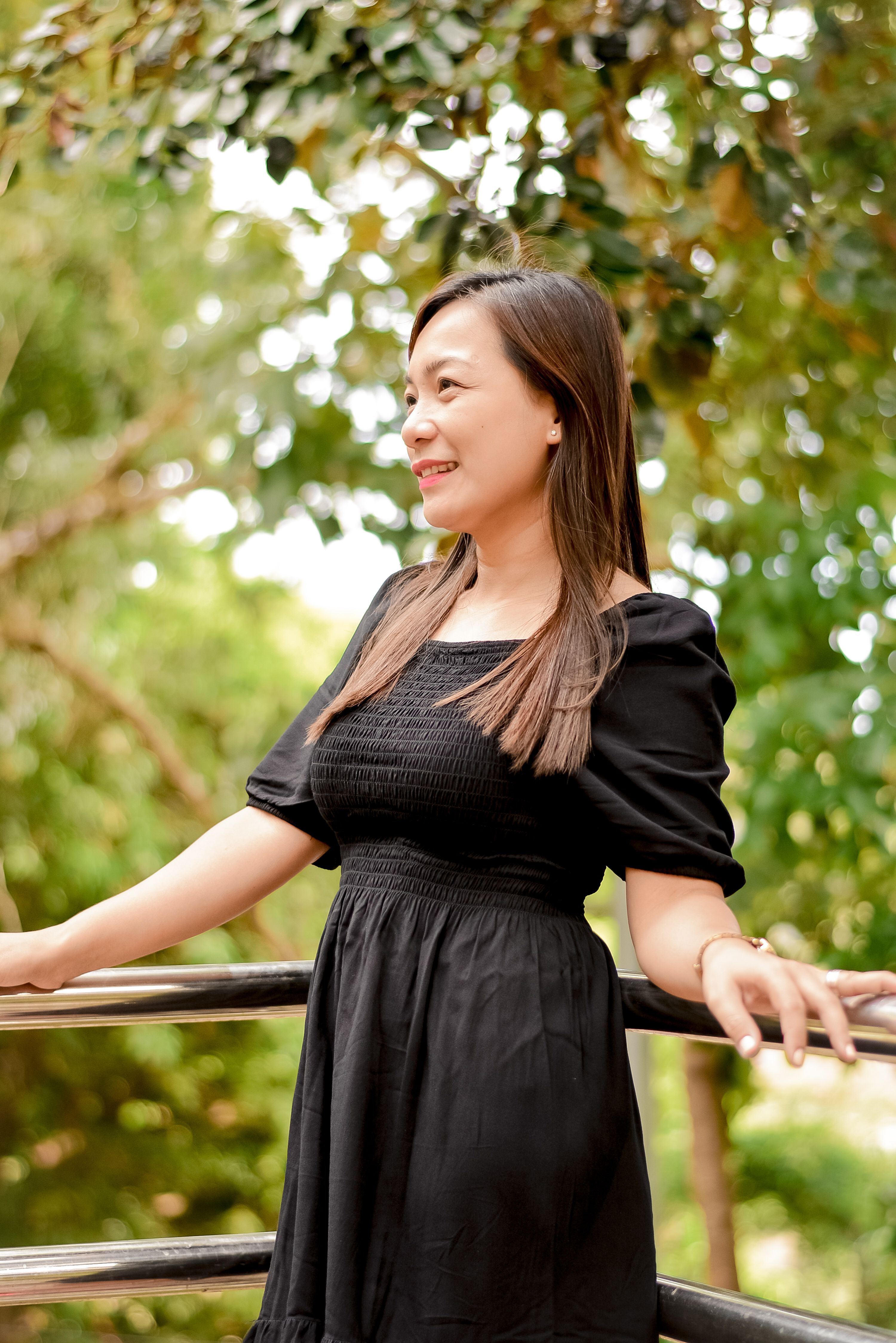 Woman in Sleeveless Dress Leaning on Metal Railing · Free Stock Photo