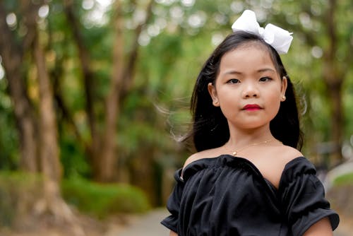 Little Girl in Black Top and Wearing White Ribbon on Head
