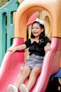 Woman in Black and White Polka Dot Dress Sitting on Pink Slide