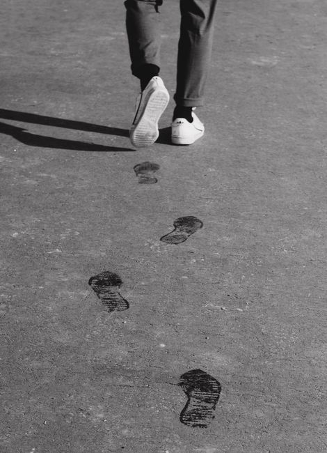 Monochrome image showing footprints and a person walking on concrete pavement in Arkhangelsk, Russia.