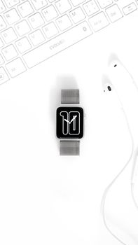 Sleek smartwatch with earphones on a minimalist white surface, perfect tech accessory display.