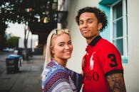 一对快乐的年轻夫妇在城市街道上微笑，画面捕捉到了友谊与幸福