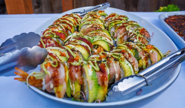 Vibrant sushi rolls elegantly arranged on a plate, garnished with avocado and sauces.