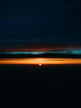 Captivating sunset with dark clouds and vibrant colors creating a dramatic horizon.